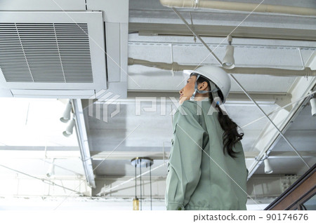 Female air conditioning equipment engineer checking the site 90174676