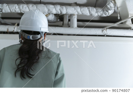 Female air conditioning equipment engineer checking the site Female air conditioning equipment engineer checking the site 90174807