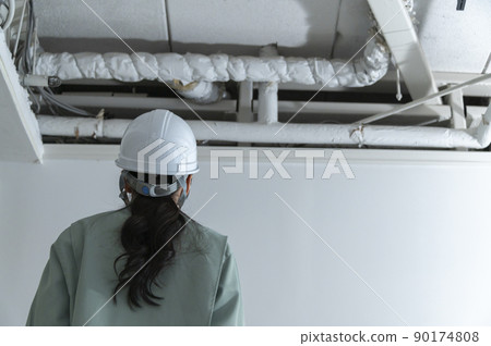 Female air conditioning equipment engineer checking the site Female air conditioning equipment engineer checking the site 90174808