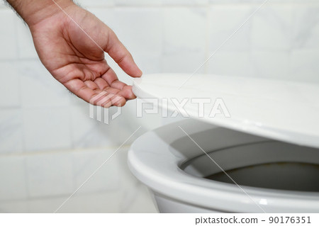 man's hand opening the toilet lid man's hand opening the toilet lid 90176351