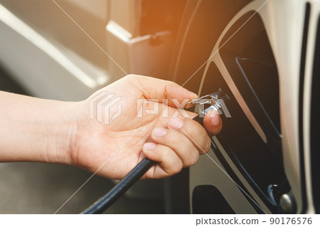 close up hand man car parking a check and inflate the tire fill up the air for safe driving on the go. Transportation travel vehicle concept. 90176576