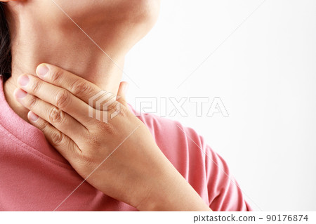 sore throat pain. Closeup of young woman sick holding her inflamed throat using hands to touch the ill neck in blue shirt on gray background. Medical and healthcare concept. Focus red on to show pain. sore throat pain. Closeup of young woman sick holding her inflamed throat using hands to touch the ill neck in blue shirt on gray background. Medical and healthcare concept. Focus red on to show pain. 90176874
