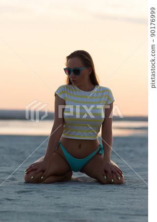 Sexy woman in t shirt sitting on beach 90176999