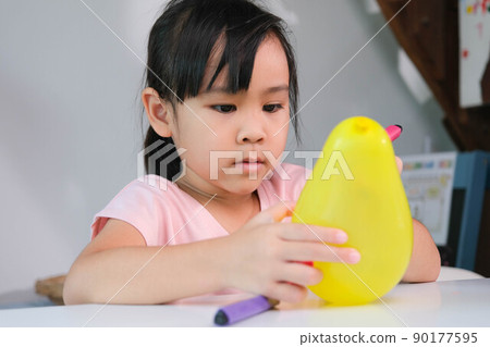 Little girl is learning and doing electrostatic science experiments with balloons in the classroom. Easy and fun science experiments for kids at home. Little girl is learning and doing electrostatic science experiments with balloons in the classroom. Easy and fun science experiments for kids at home. 90177595