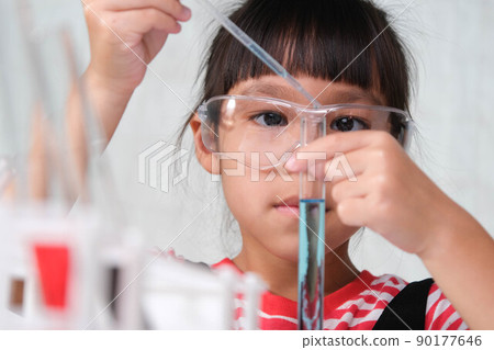 Children are learning and doing science experiments in the classroom. Little girl playing science experiment for home schooling. Easy and fun science experiments for kids at home. 90177646