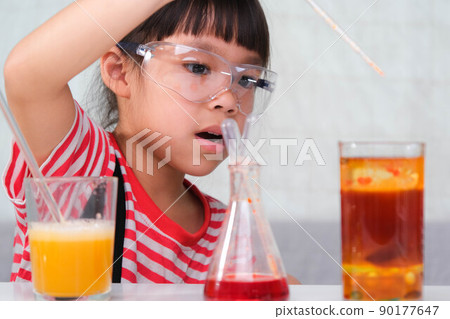 Children are learning and doing science experiments in the classroom. Little girl playing science experiment for home schooling. Easy and fun science experiments for kids at home. 90177647