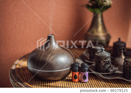 Aroma oil diffuser with aroma oil on table at home. Air freshener 90179125