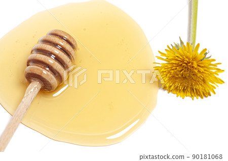 Wooden dipper with honey and dandelion isolated on a white background. Golden organic floral honey natural. 90181068