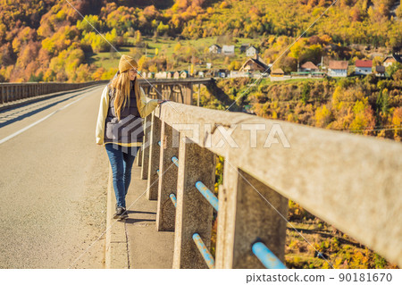 Montenegro. Woman touriste in background of Dzhurdzhevich Bridge Over The River Tara foggy morning. Travel around Montenegro concept. Sights of Montenegro 90181670