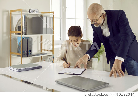 Happy client signs some documents given by her lawyer, loan broker or real estate agent 90182014