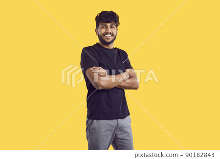 Happy handsome young Indian man in casual clothes standing isolated on yellow background Happy handsome young Indian man in casual clothes standing isolated on yellow background 90182843