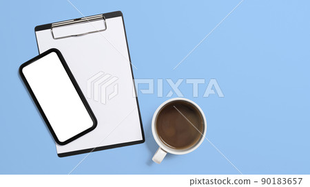 Top view mockup smart phone, clipboard and coffee cup on blue background. Copy space, blank screen for advertise text 90183657