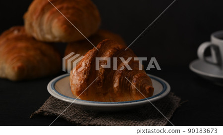 Freshly baked croissants and coffee cup on wooden table. Levitation, bread bakery products cafe concept 90183673