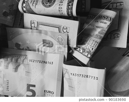 Cash banknotes dollars and euros are mixed up, a close-up shot. Black and white image. Cash banknotes dollars and euros are mixed up, a close-up shot. Black and white image. 90183698