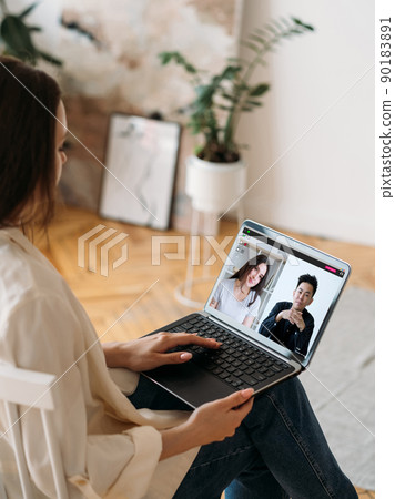 Video interview. Virtual meeting. Web conference. Female leader working from home discussing project online with diverse business team on laptop screen in digital office. 90183891