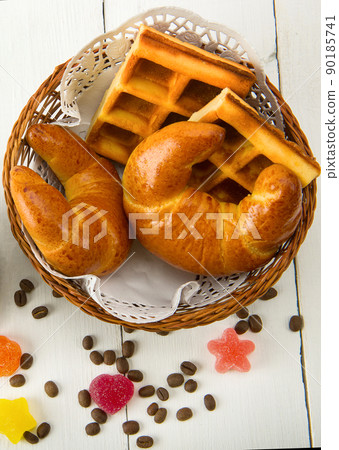 Waffles and croissants in a basket isolated on white background. 90185741