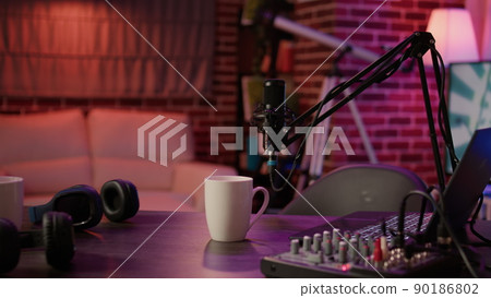 Nobody in podcast home studio with microphone boom arm and audio recording professional mixer on desk. Empty internet online radio setup for producing podcasts for social media. Nobody in podcast home studio with microphone boom arm and audio recording professional mixer on desk. Empty internet online radio setup for producing podcasts for social media. 90186802
