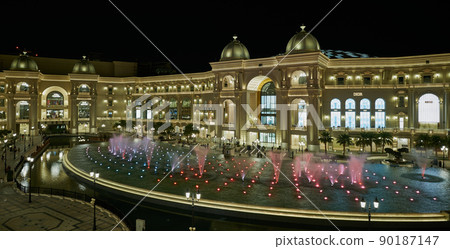 Place Vendome Mall  in Lusail city, Qatar interior view at night showing the architecture of the mall with big fountain in foreground  90187147