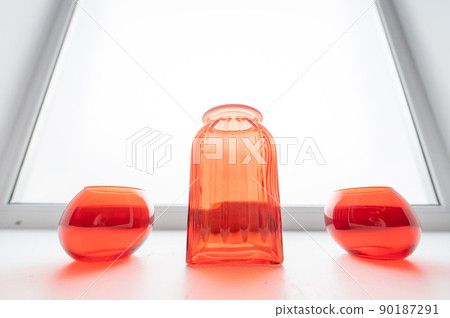Three empty glass red vases on the windowsill. Three empty glass red vases on the windowsill. 90187291