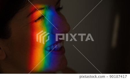 Close-up portrait of caucasian woman with ray of rainbow light on her face. Close-up portrait of caucasian woman with ray of rainbow light on her face. 90187417