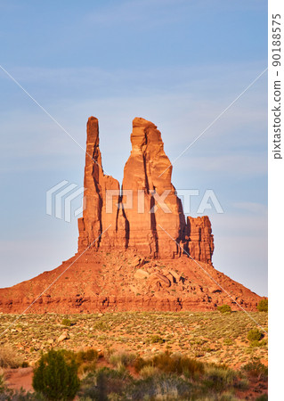 Vertical large red rock pillar in desert with blue sky Vertical large red rock pillar in desert with blue sky 90188575