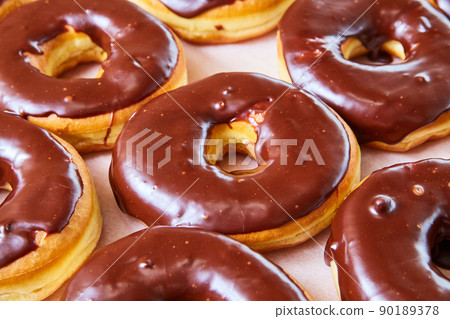 Delicious tray of yeast donuts with chocolate sauce on top Delicious tray of yeast donuts with chocolate sauce on top 90189378
