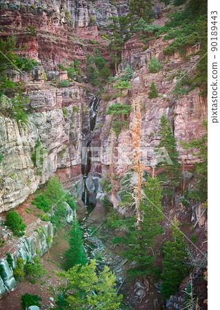 Deep canyon with scenic waterfall in the distance and river Deep canyon with scenic waterfall in the distance and river 90189443