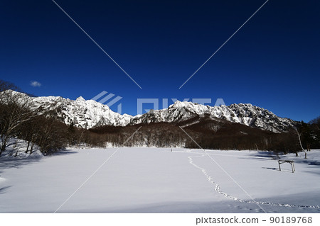 Togakushi Kagamiike pond in winter White Togakushi mountain and Kagamiike pond with blue sky and snow 90189768