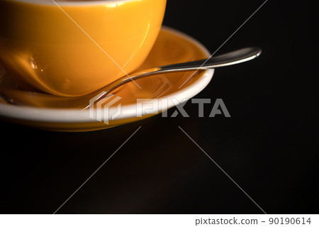Yellow tea or coffee cup and plate on dark background 90190614