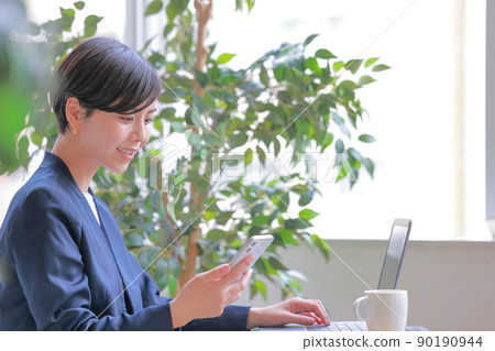 Business woman looking at a smartphone 1 90190944
