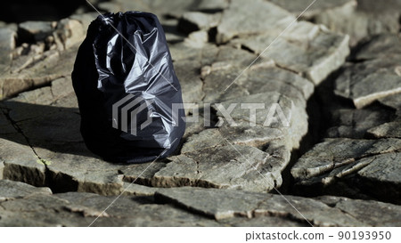 black trash bag lay on a rocky beach black trash bag lay on a rocky beach 90193950