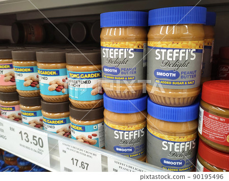SELANGOR, MALAYSIA -MAY 24, 2022: Peanut butter in commercial bottles is on display for sale in stores. Labeled by brand and price tagged for customer convenience. SELANGOR, MALAYSIA -MAY 24, 2022: Peanut butter in commercial bottles is on display for sale in stores. Labeled by brand and price tagged for customer convenience. 90195496