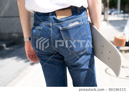 Male penny cruiser with skateboard back view 90196315