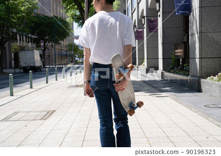 Male penny cruiser with skateboard back view Male penny cruiser with skateboard back view 90196323