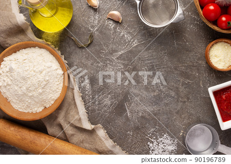 Homemade pizza  with ingredients on table. Flour for pizza at tabletop 90196789