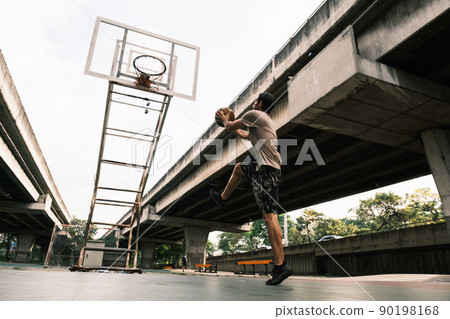Two caucasian men pratice baskegball in court at urban street. 90198168