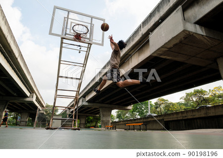 Two caucasian men pratice baskegball in court at urban street. 90198196