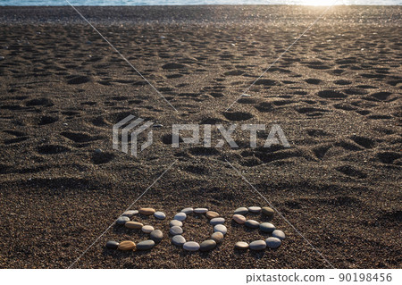 SOS message made with stones on the beach 90198456