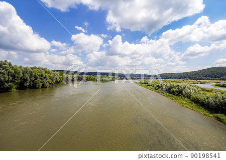 Water in wide river in summer with green trees on the banks 90198541