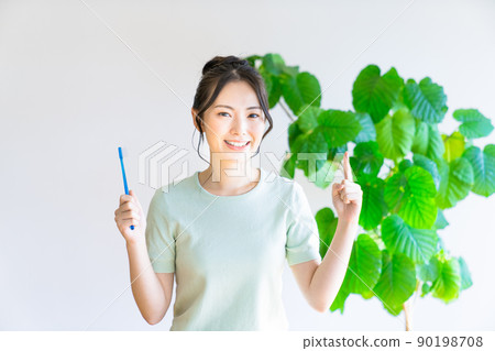 A young woman pointing with a toothpaste 90198708