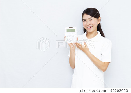 30多歲的美容診所工作人員拿著計算器 90202630