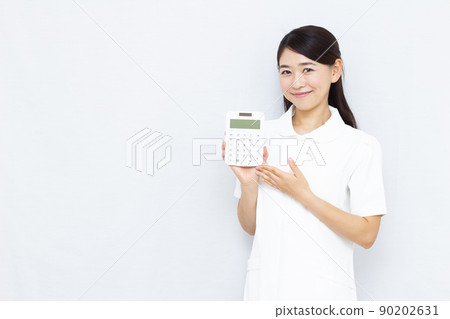 30多歲的美容診所工作人員拿著計算器 90202631