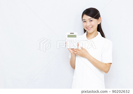 30多歲的美容診所工作人員拿著計算器 90202632