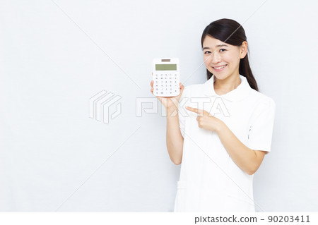 30多歲的美容診所工作人員拿著計算器 90203411