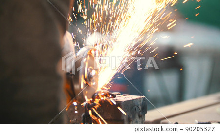 Industrial concept. Construction site. The man worker grinding. Fire sparkles 90205327