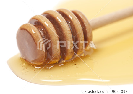 Wooden dipper with honey isolated on a white background. Golden organic floral honey natural. Wooden dipper with honey isolated on a white background. Golden organic floral honey natural. 90210981