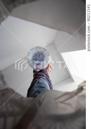 Man putting empty plastic bottle in recycling bin. Person in the house kitchen separating waste Man putting empty plastic bottle in recycling bin. Person in the house kitchen separating waste 90211541
