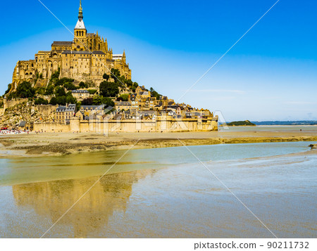 Le Mont Saint Michel, impressive view of the famous abbey during low tide on a bright sunny day, Normandy, Northern France Le Mont Saint Michel, impressive view of the famous abbey during low tide on a bright sunny day, Normandy, Northern France 90211732