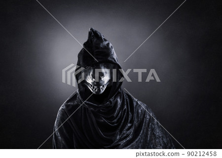 Reptile in hooded cloak at night over dark misty background 90212458