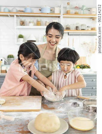 Happy Asian family making food in kitchen at home. Enjoy family activity together. Happy Asian family making food in kitchen at home. Enjoy family activity together. 90214252